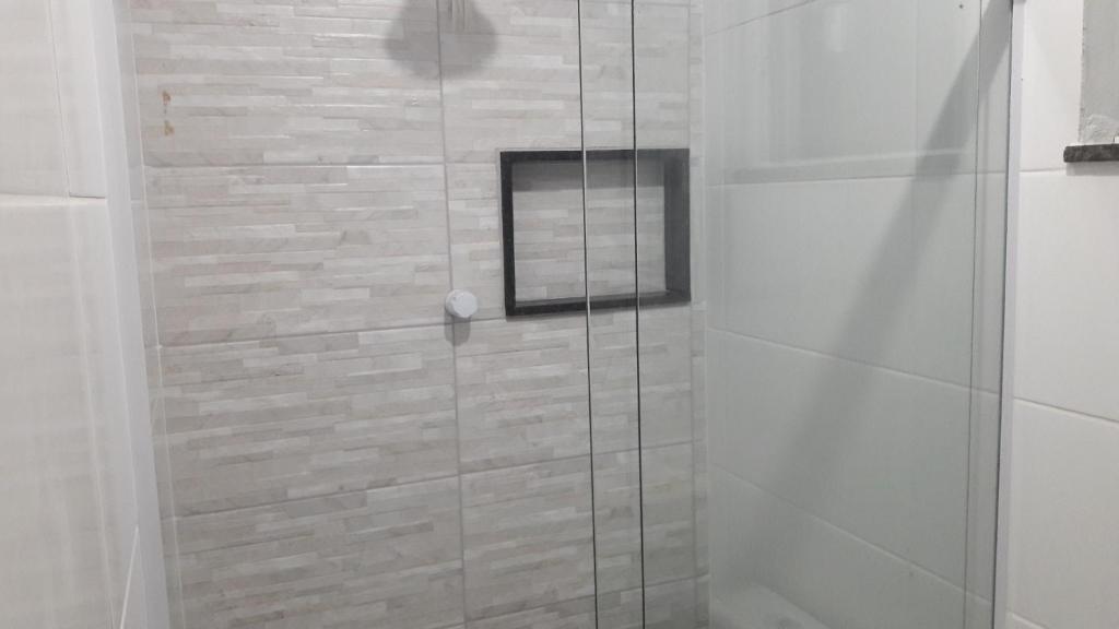 y baño con ducha y puerta de cristal. en Casa em Arraial do Cabo, en Arraial do Cabo