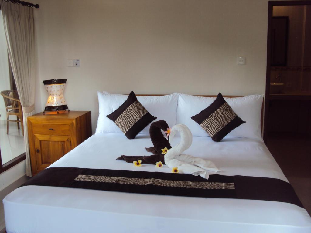 a bed with two swans and a swan on it at Soka Homestay in Ubud