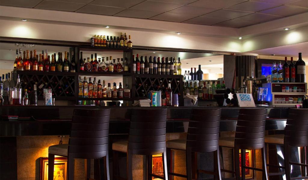a bar with a lot of bottles of alcohol at BWC Hotel in Lagos