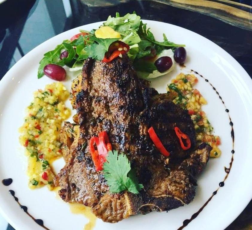 a plate of food with meat and vegetables on a table at BWC Hotel in Lagos