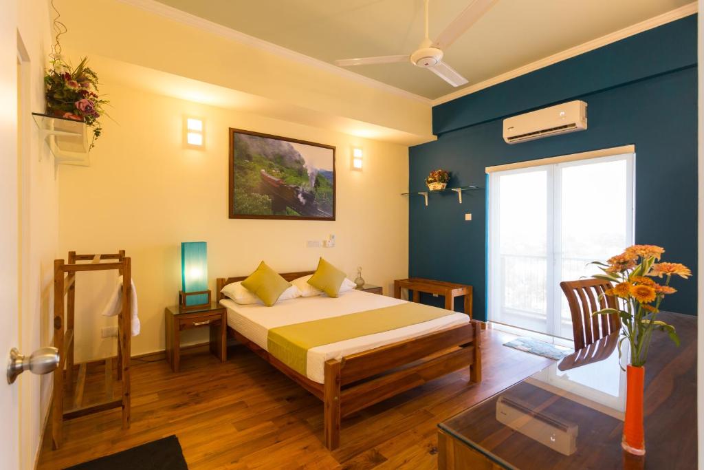 a bedroom with a bed and a blue wall at Shalom Residence Nawala in Colombo