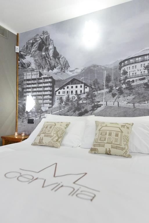 łóżko z górskim malowidłem na ścianie w obiekcie Mollino Rooms w mieście Breuil-Cervinia