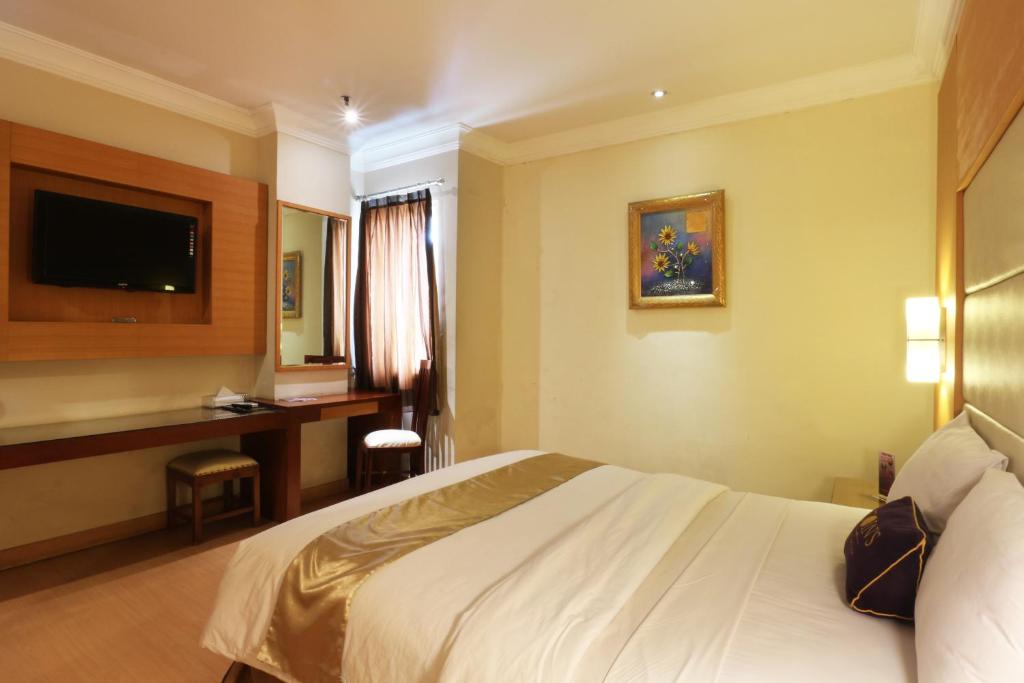 Postel nebo postele na pokoji v ubytování Coins Hotel Jakarta