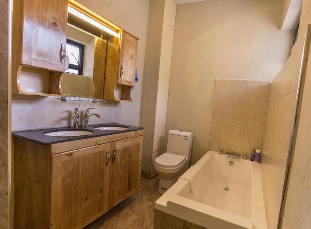 a small bathroom with a sink and a toilet at Ibis Apartments in Kampala