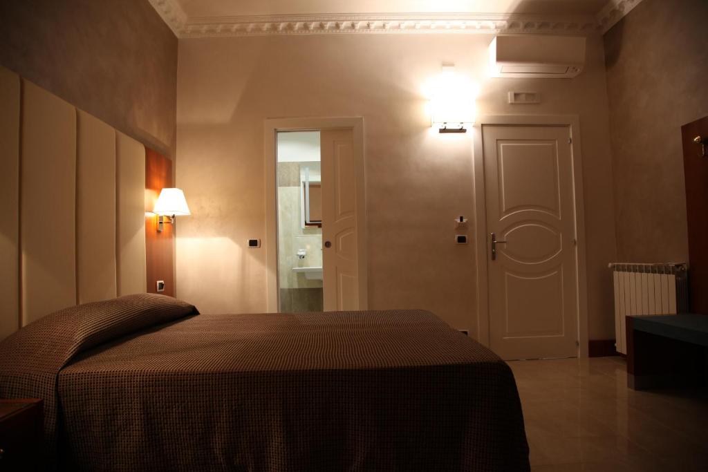 ローマにあるB＆B フェデリカズ ハウス イン ローマのベッドルーム1室(ベッド1台付)、ドア(照明付)