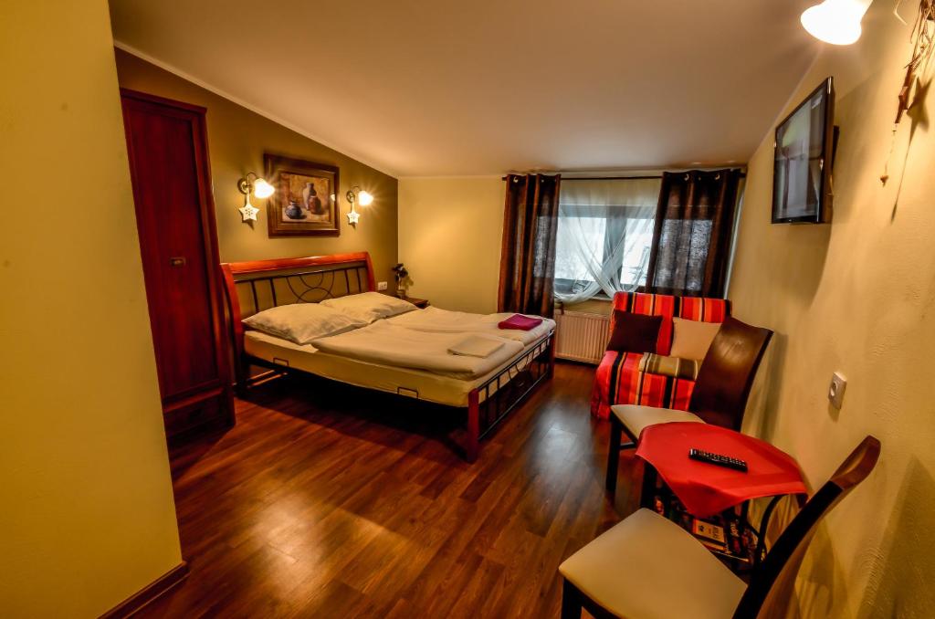 1 dormitorio con 1 cama, mesa y sillas en Pokoje BALDI Benelux, en Skoczów