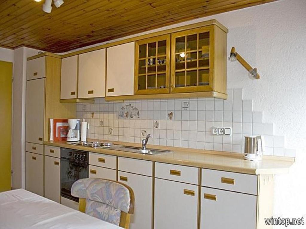 a kitchen with white cabinets and a sink at Ferienwohnung Pinker in Grafenau