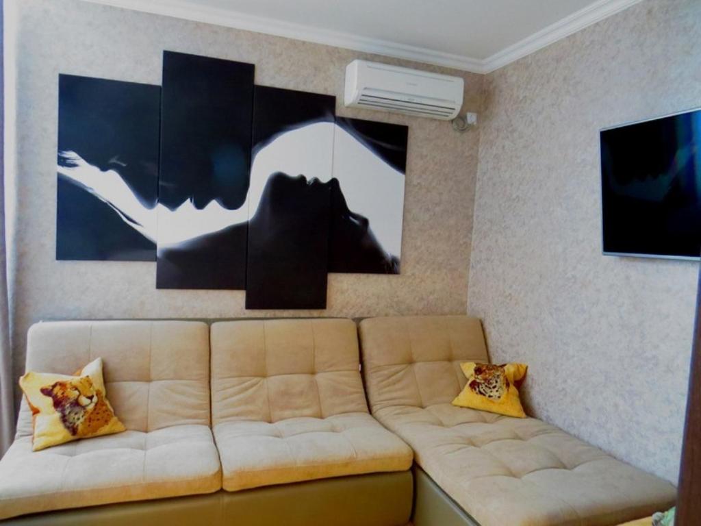 een woonkamer met een bank en een schilderij aan de muur bij Apartment on Svobodu ave in Sumy
