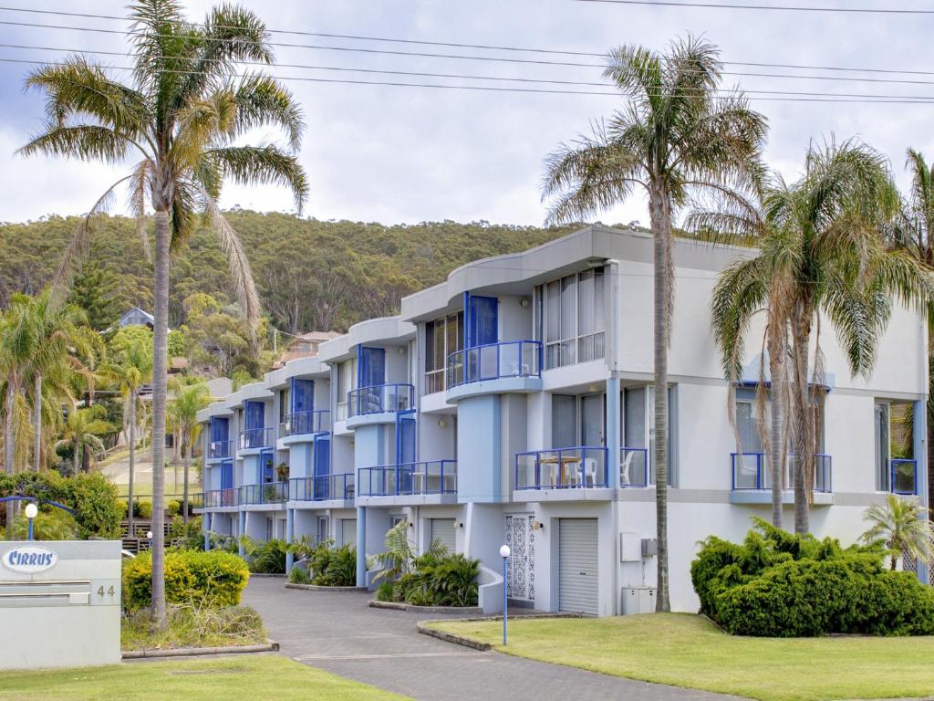 un edificio con balcones azules y palmeras en Cirrus 6 44 Marine Drive, en Fingal Bay