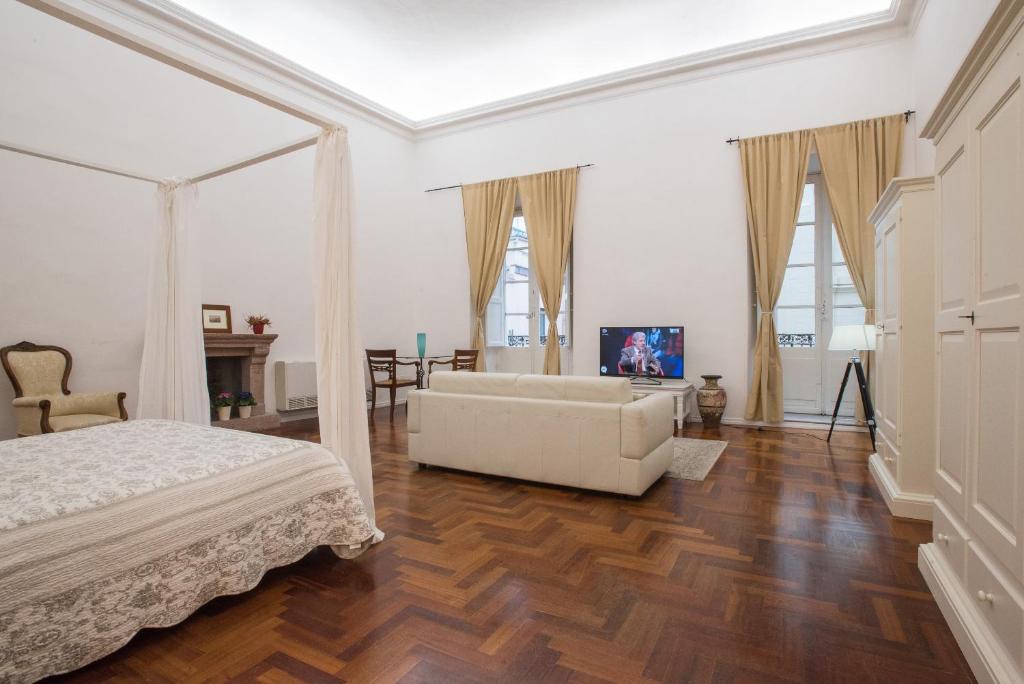 カリアリにあるResidenze al Castelloの白いベッドルーム(ベッド1台、ソファ付)
