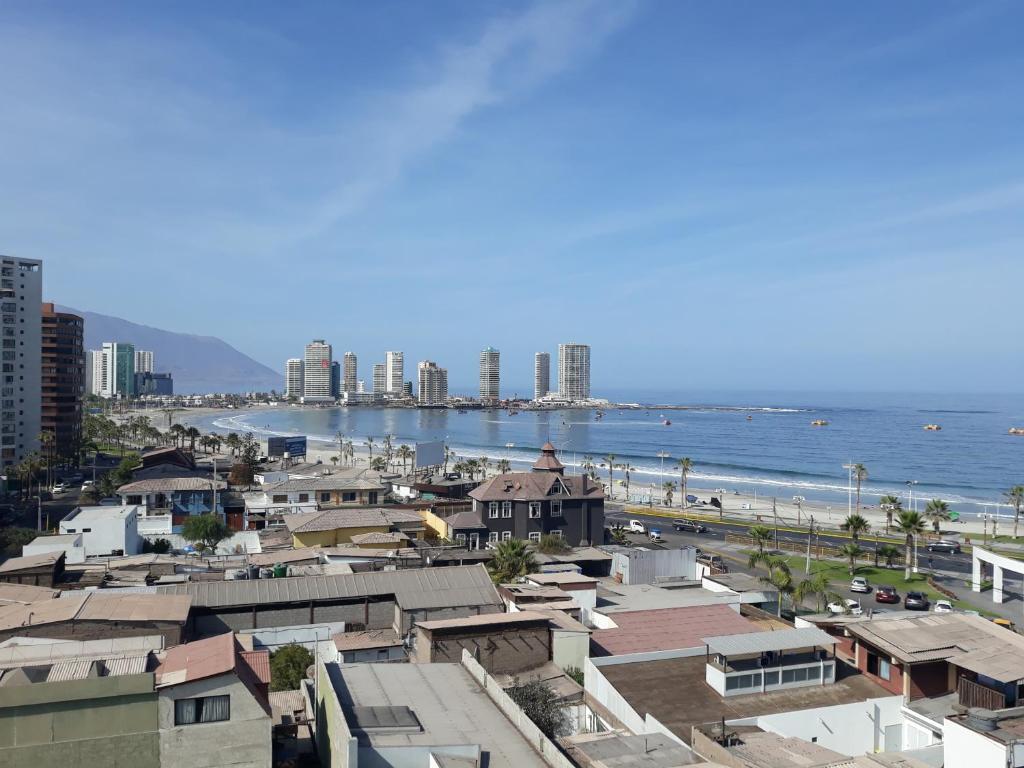 vistas a una ciudad con edificios y al océano en Playa Hotel Stay Work & Play Cavancha en Iquique