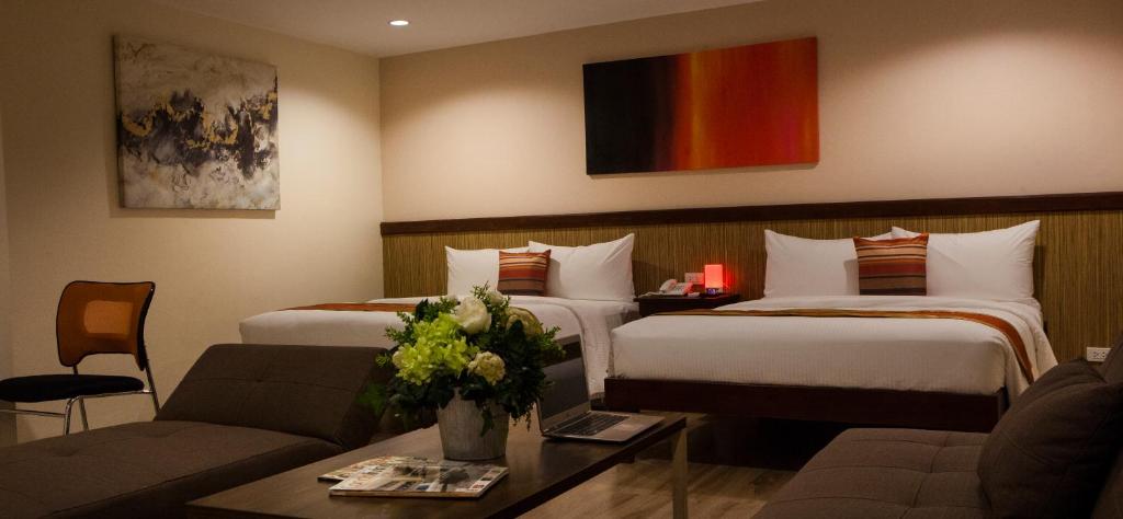 a hotel room with two beds and a couch at NS Royal Hotel in Cebu City
