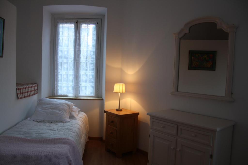 a bedroom with a bed and a table with a lamp at Casa Lawrence in Brisino
