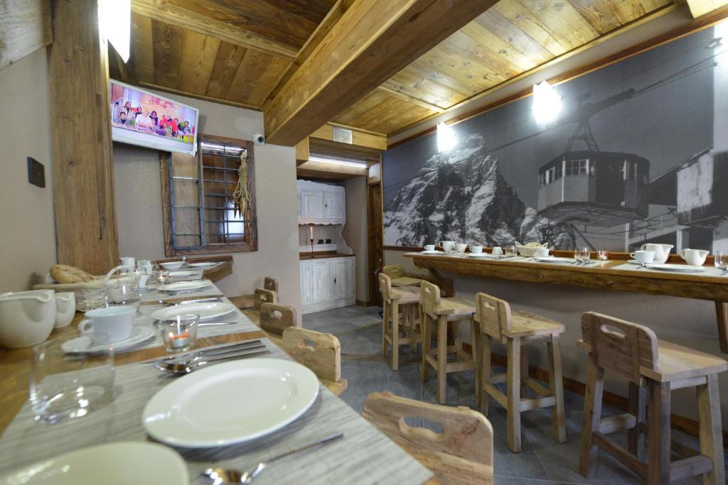 restauracja ze stołami i krzesłami oraz kuchnia w obiekcie Mollino Rooms w mieście Breuil-Cervinia