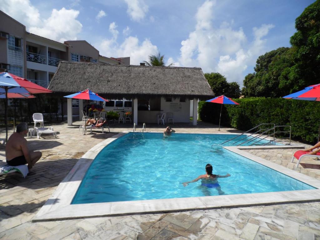 une personne se baignant dans une piscine dans l'établissement Flat Luxo Ponta Negra, à Natal