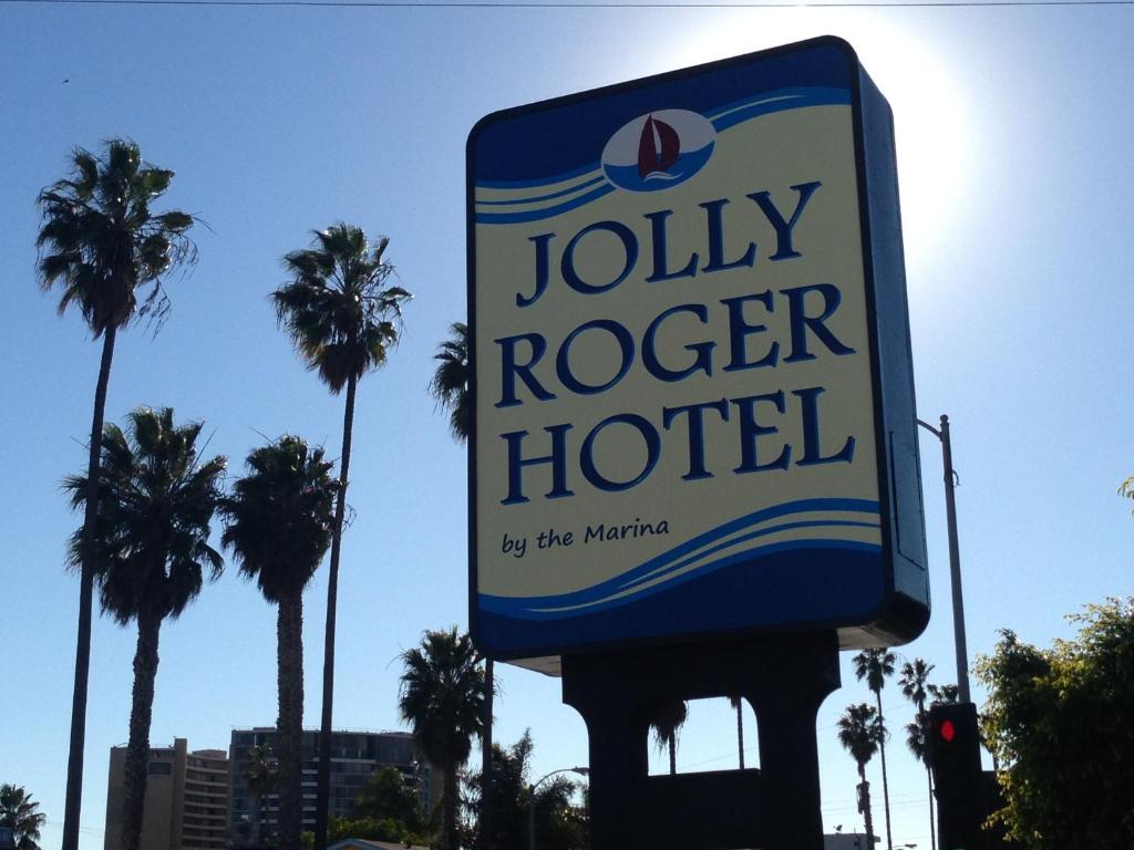 a sign for a jolly roger hotel with palm trees at Jolly Roger Hotel in Los Angeles