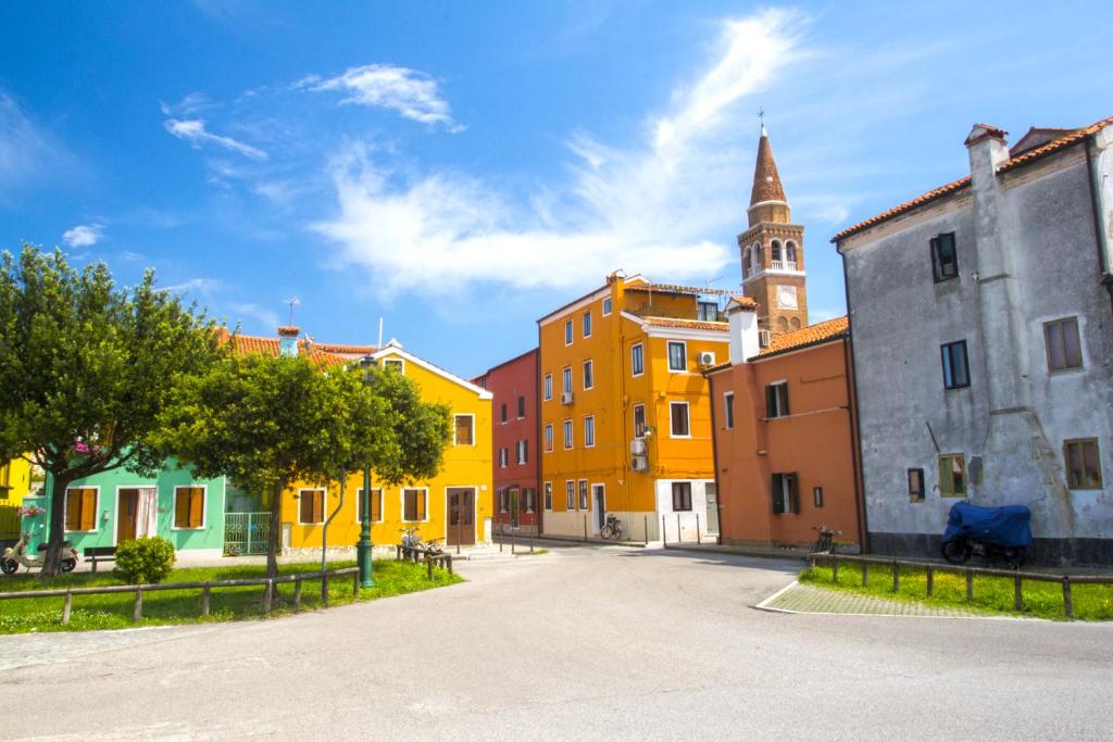 a street with colorful buildings and a church at Locanda Stravedo in Pellestrina