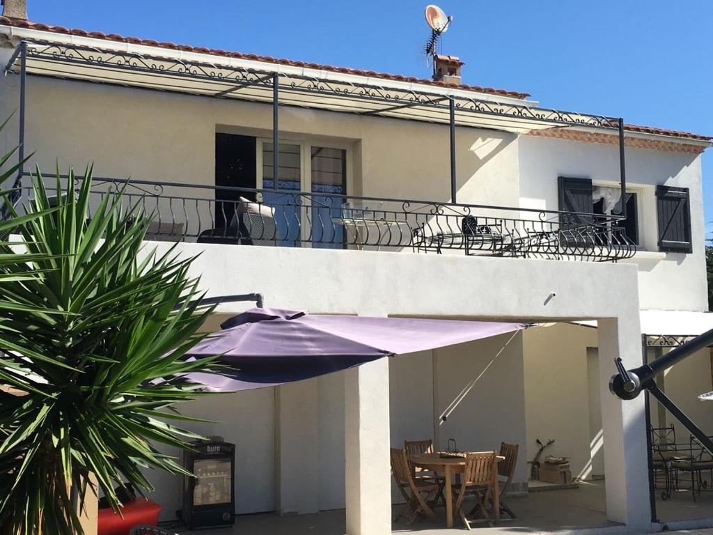 une maison avec un parasol violet et un balcon dans l'établissement Appartement Janas , Haut de villa 90m2, à La Seyne-sur-Mer