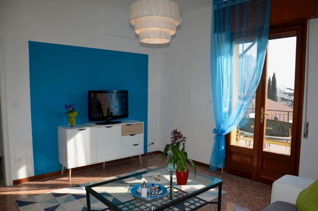 salon z telewizorem i niebieską ścianą w obiekcie Appartamento Le Vele w mieście Garda
