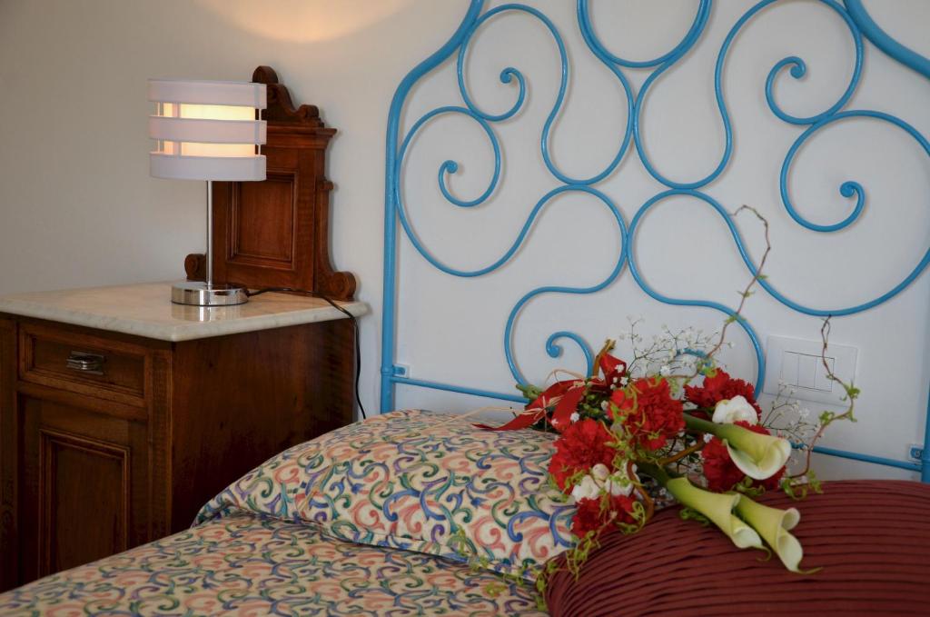 um quarto com uma cama com um ramo de flores em Appartamento Le Vele em Garda