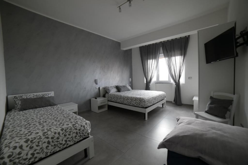 sypialnia z dwoma łóżkami i telewizorem na ścianie w obiekcie SaMi B&B w mieście Scalea