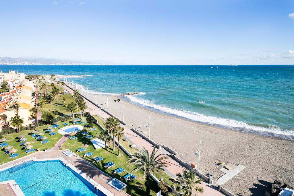 a beach area with a beach chair and a balcony overlooking the ocean at Sol Guadalmar in Málaga