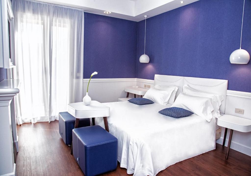 リミニにあるVilla Adriatica Ambienthotelsのベッドルーム1室(白いベッド1台、青い壁付)