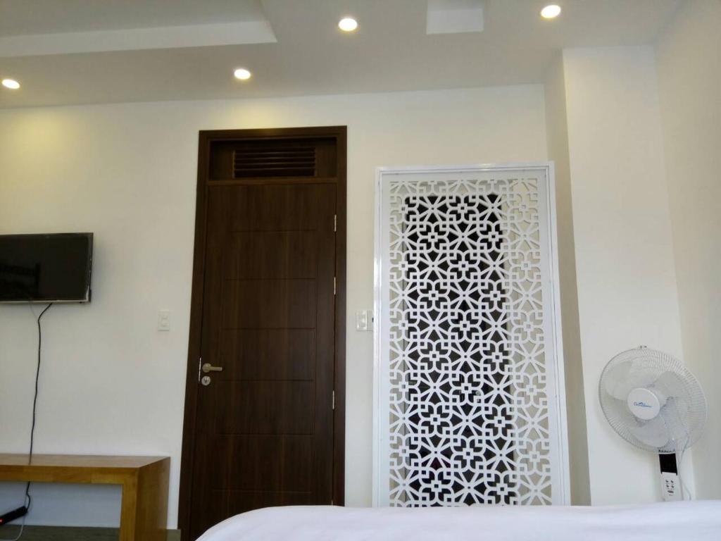 een slaapkamer met een deur met een wit raam bij Khách sạn mini Khang Thịnh in Da Lat