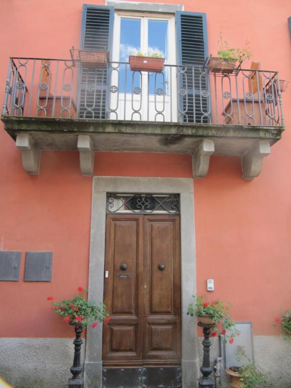 um edifício com uma porta de madeira e uma varanda em tuscanrooms apartment em Lucca