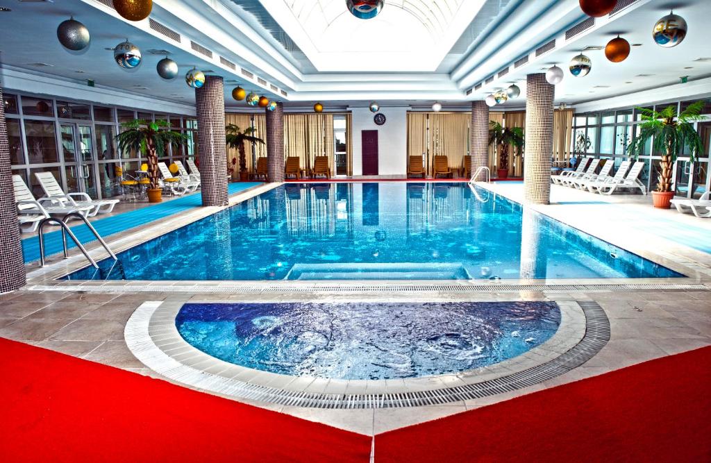una grande piscina in un hotel con pavimento rosso di Grand Hotel Victory ad Aqtau