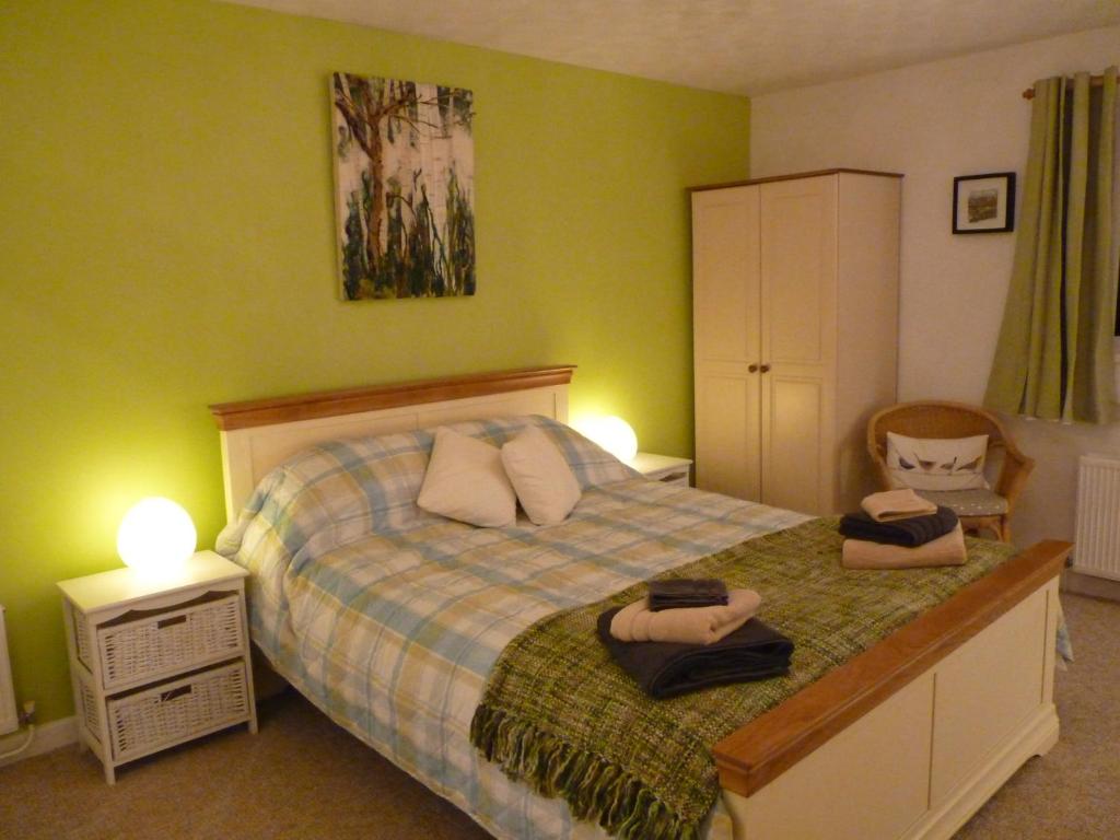 a bedroom with a bed with two towels on it at The Farthings in Braunton