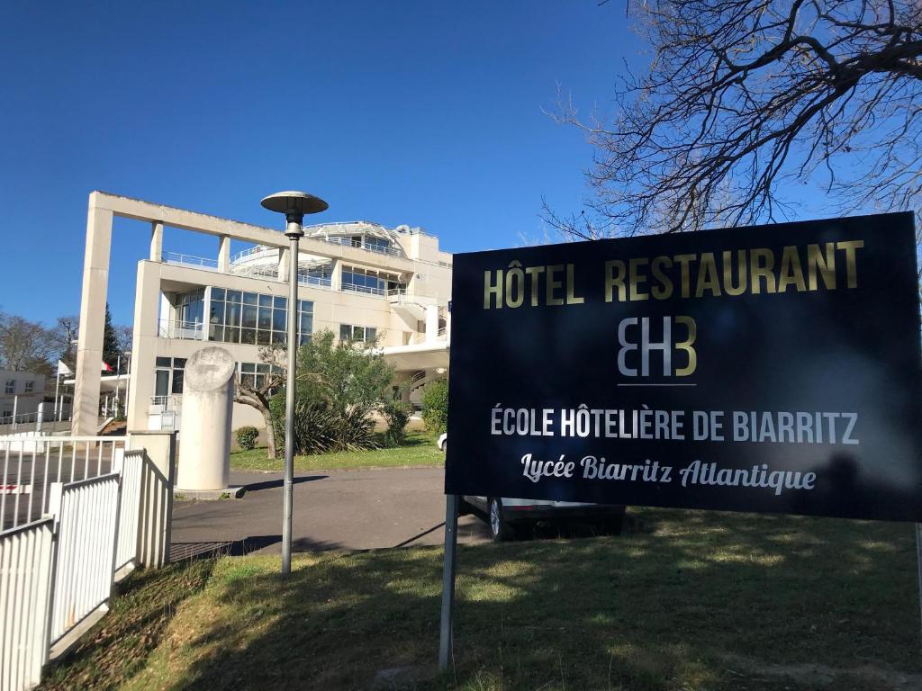 una señal frente a un hospital con un edificio en Hotel Biarritz Atlantique - Lycée Hotelier - Management School, en Biarritz