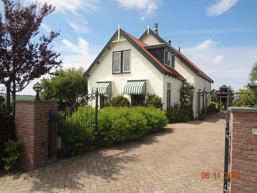 a white house with a red roof and a driveway at B&B Landleven in Hellevoetsluis