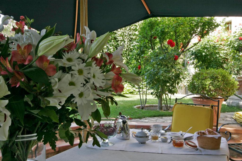 einen Tisch mit einem weißen Tischtuch und Blumen darauf in der Unterkunft Maison De La Bourgade in Uzès