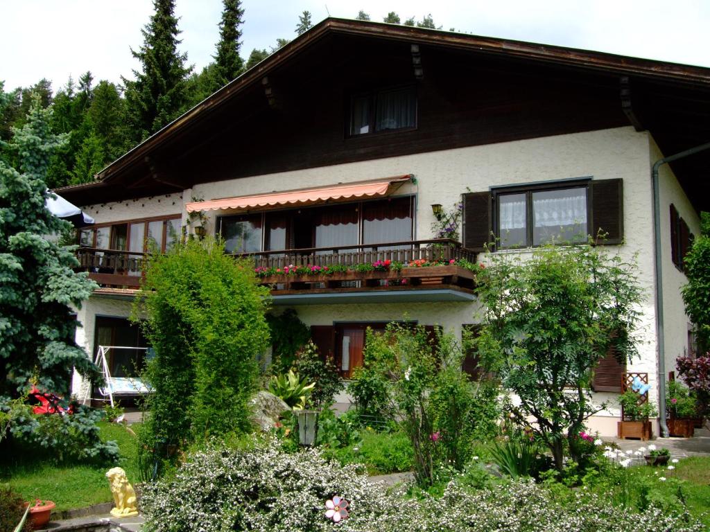 a house with a balcony with flowers on it at Pension Krüger in Seeboden