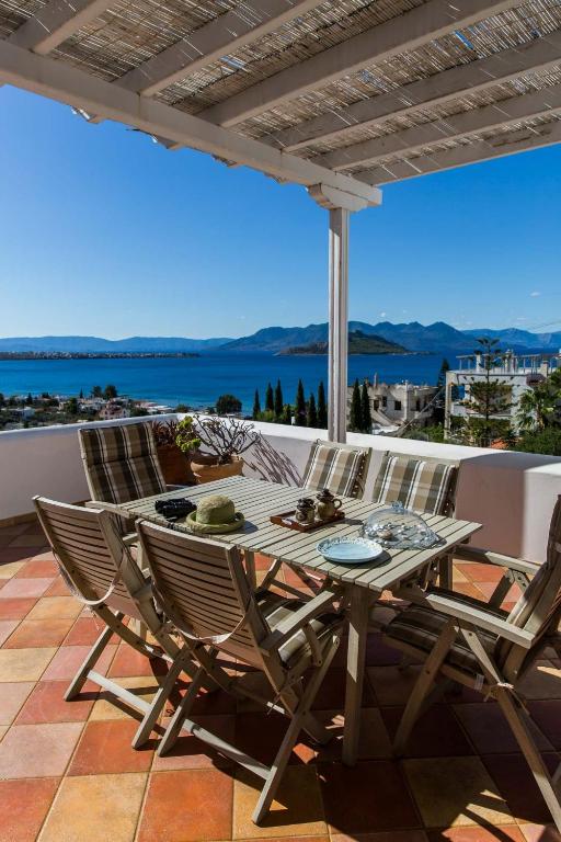a table and chairs on a patio with a view of the ocean at Villa Euphoria in Aegina, A' Marathonas bay in Egina