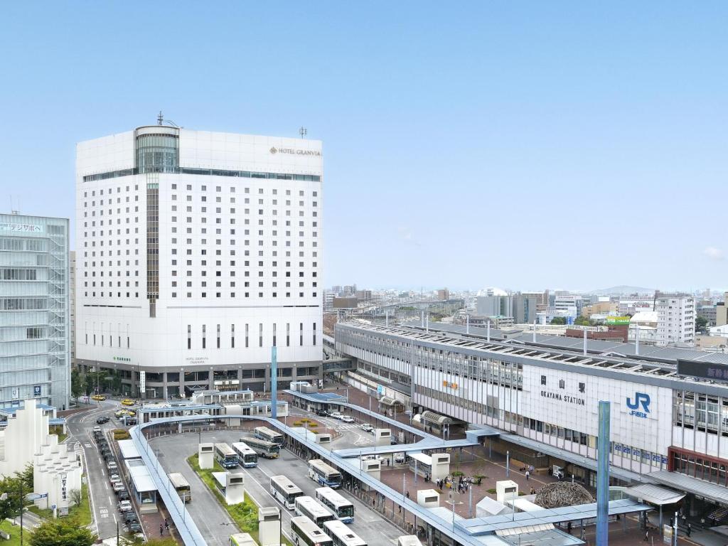 
a large building with a lot of cars parked in front of it at Hotel Granvia Okayama in Okayama
