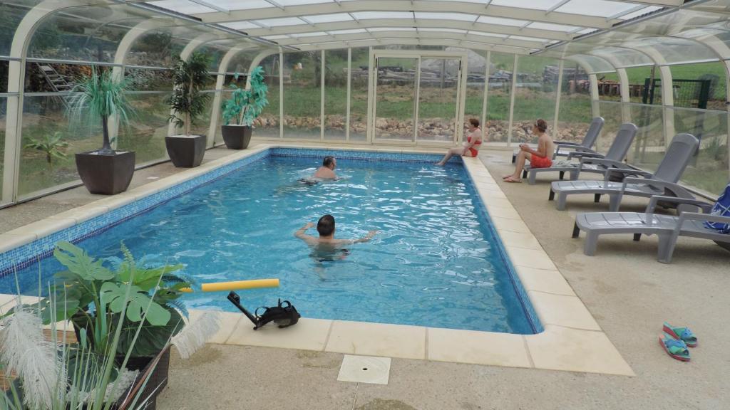 eine Gruppe von Personen, die in einem Schwimmbad schwimmen in der Unterkunft Le Mas de Cascabel in Causse et Diege