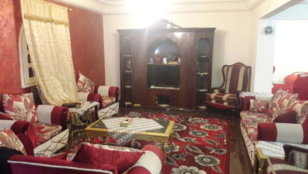 ein Wohnzimmer mit Sofas, Stühlen und einem Tisch in der Unterkunft Octobar City Villa in Kairo