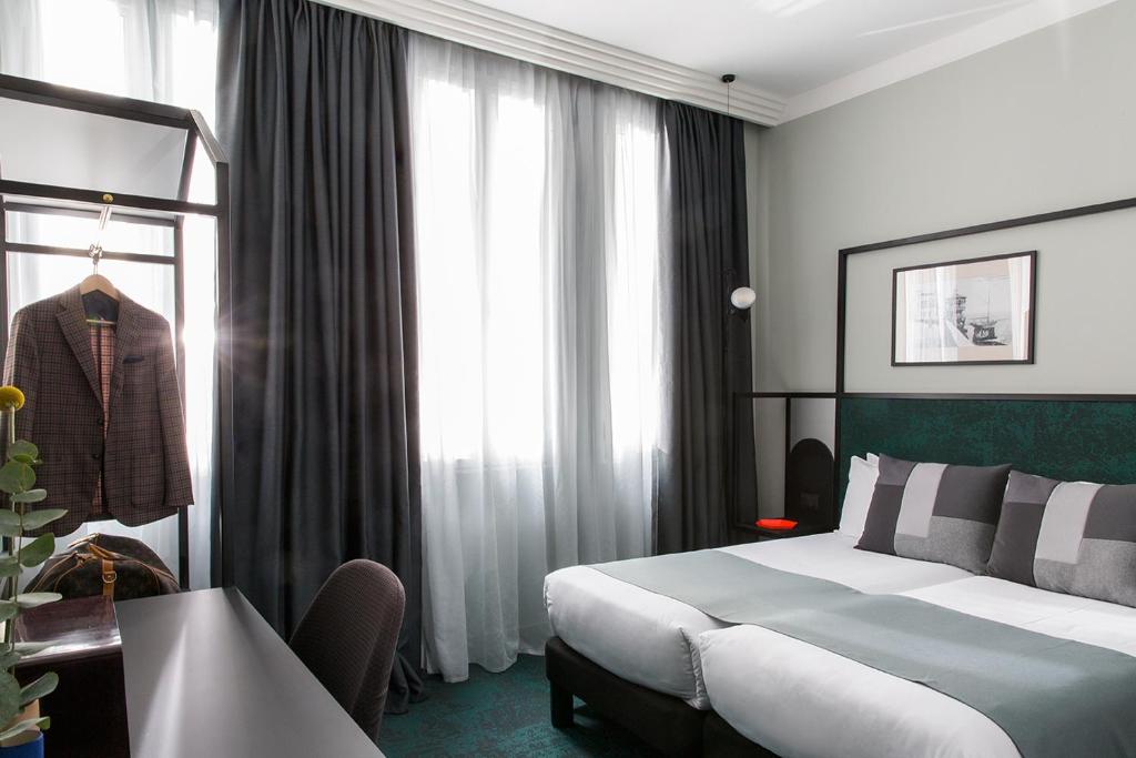 Кровать или кровати в номере Hôtel les Cigales