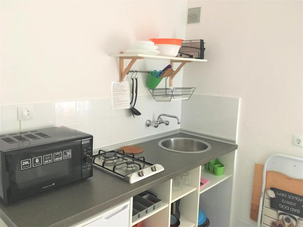 a small kitchen with a sink and a microwave at Apartamentos Calypso in Punta Umbría