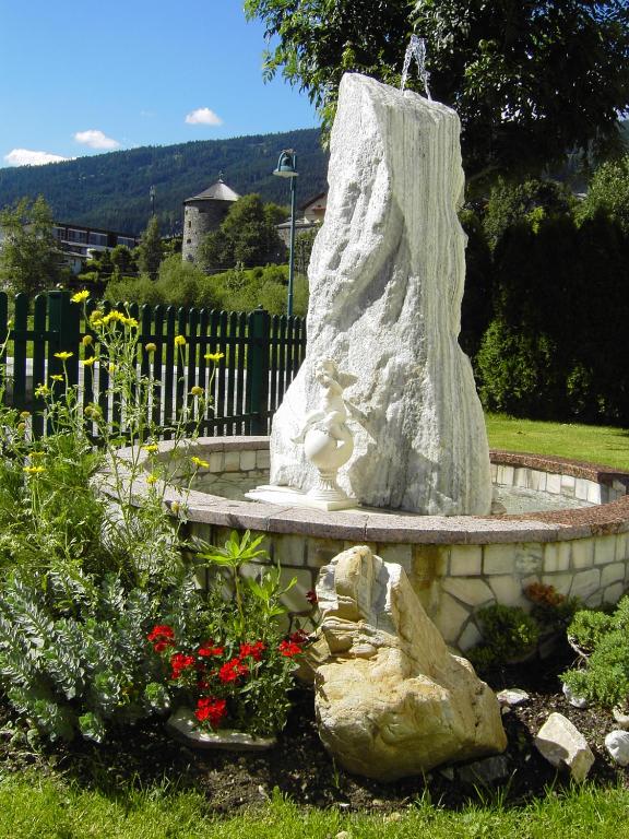 a statue of a woman sitting on a bench in a garden at Appartement Pichler in Radstadt