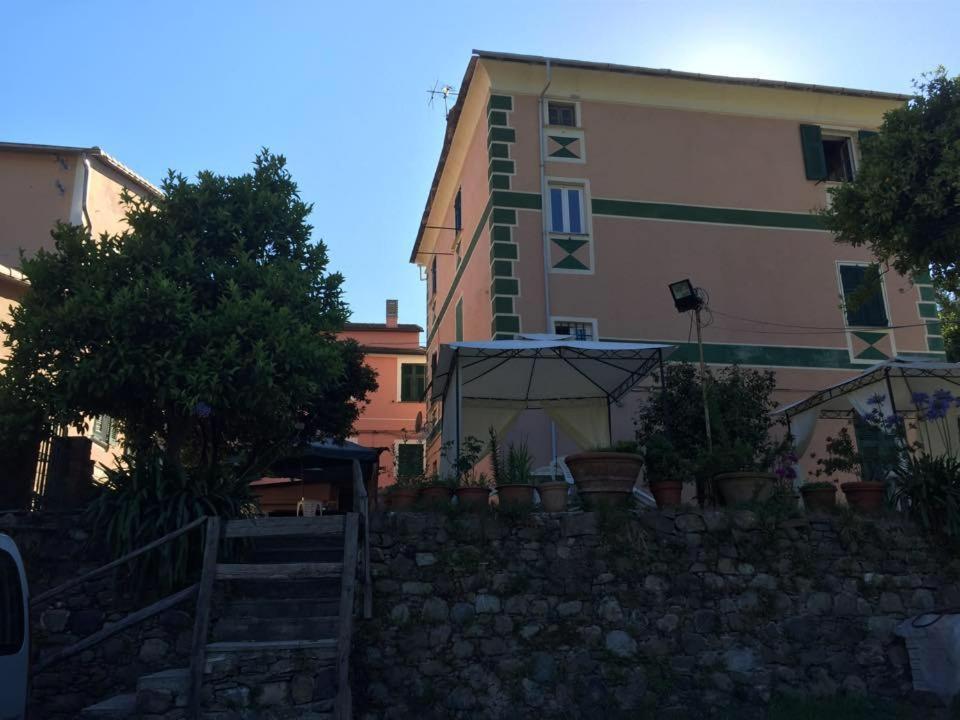 a building next to a stone wall with potted plants at B&B Ca' da Lina in Deiva Marina