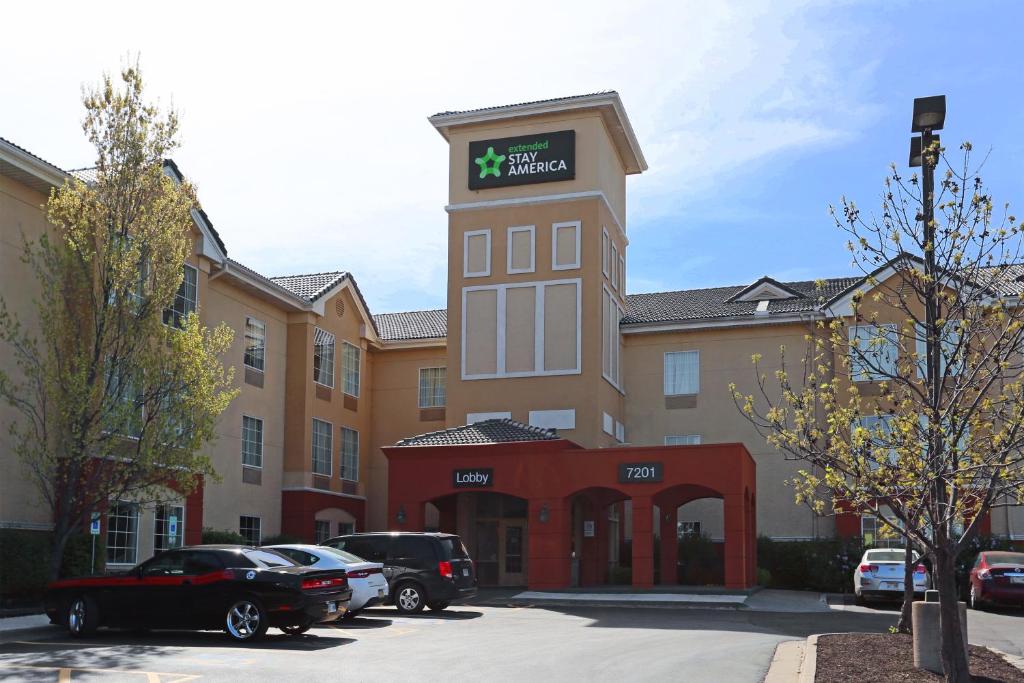 a hotel building with cars parked in a parking lot at Extended Stay America Suites - Kansas City - Overland Park - Metcalf Ave in Overland Park