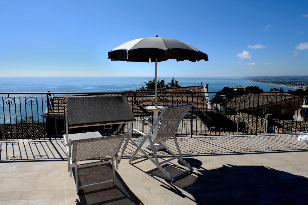 una sedia e un ombrellone in cima a un balcone di L'Orizzonte Relais Sirolo a Sirolo