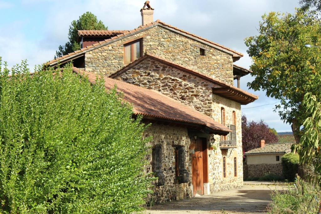 an old stone house with a roof at La Forqueta y El Fontanal in Santa María de Ordás