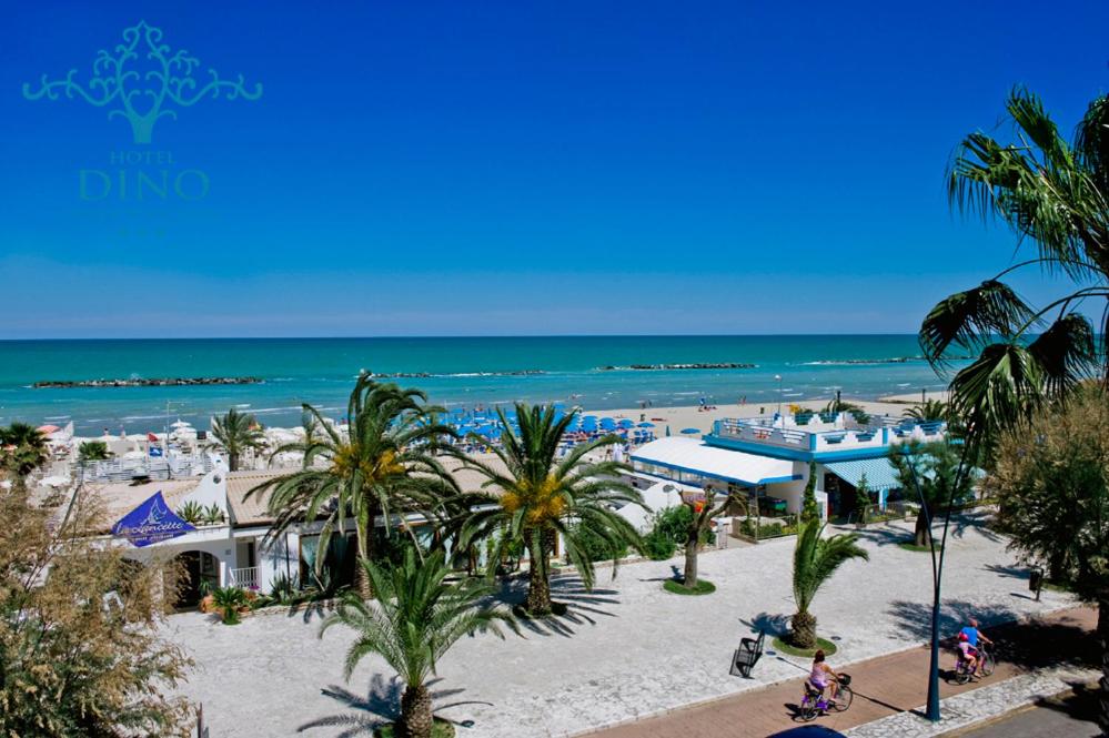 a view of a beach with palm trees and the ocean at Hotel Dino in San Benedetto del Tronto