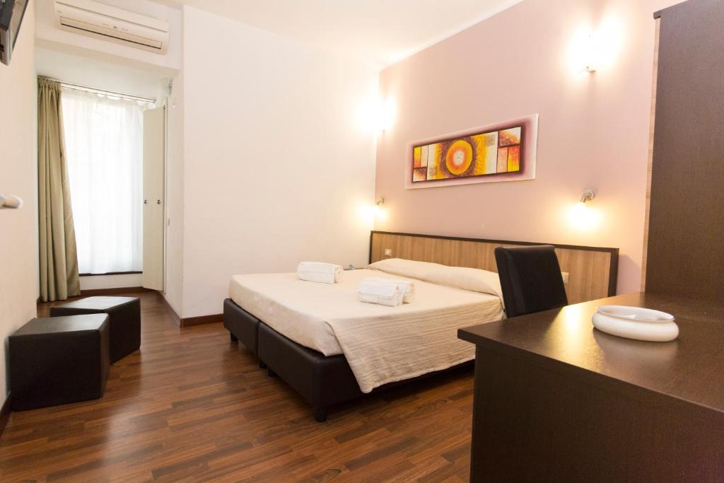 Habitación de hotel con cama y escritorio. en Lewisrooms Domo, en Cagliari