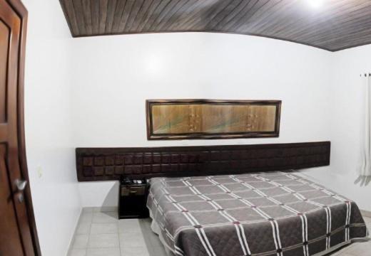 a bedroom with a bed and a mirror on the wall at Muiraquitã Hotel in Ourilândia do Norte