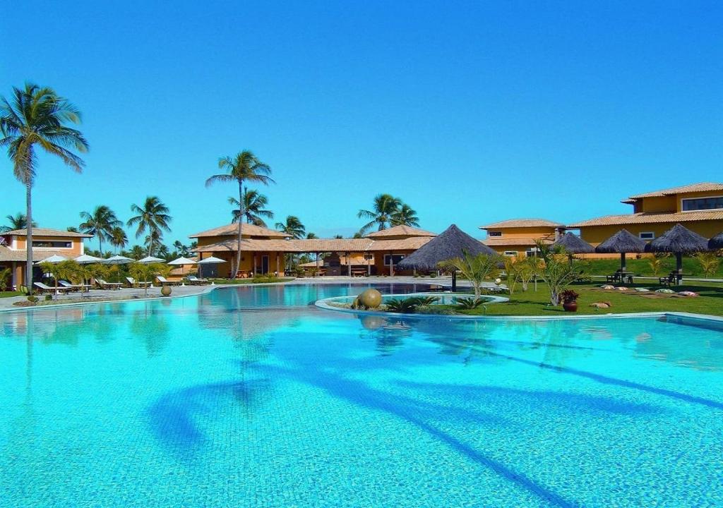 ein großer Pool in einem Resort mit Palmen in der Unterkunft Lagoa Eco Village in Pipa
